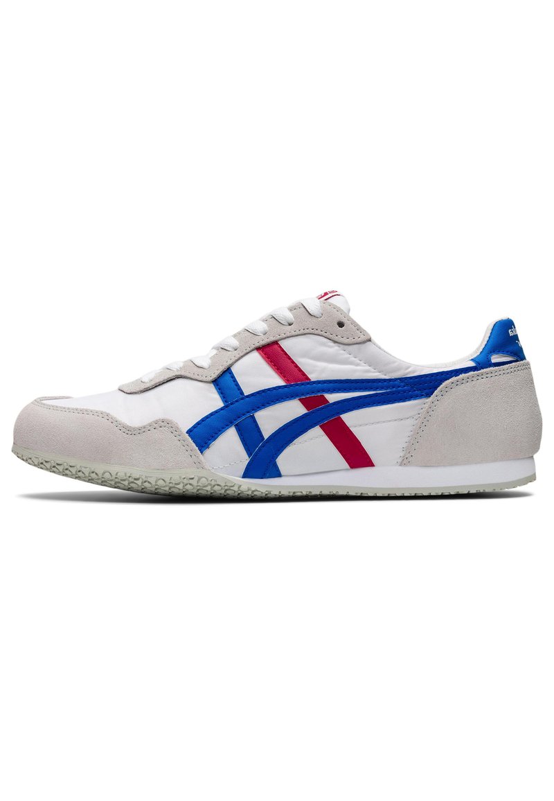Hvid sneakers med grå ruskindsdetaljer, blå og røde syntetiske striber, flade snørebånd og struktureret gummi sål. Klassisk design med sporty elementer.