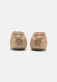 Sølvtone stoffslippers med teksturert finish, med en liten sløyfe foran og elastisk åpning for enkel påkledning.