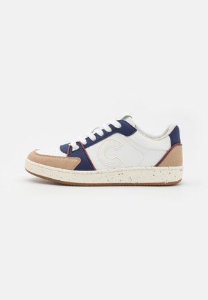Sneaker in pelle bianca e blu navy con accenti in suede color sabbia, punta arrotondata, tre lacci bianchi e suola beige maculata. Logo circolare sul lato.
