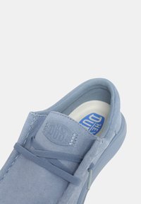 Scarpa slip-on in suede blu con punta rotonda, lacci elasticizzati e colletto imbottito; interno morbido con soletta brandizzata.