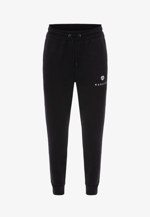 Sorte sweatpants lavet af blødt stof, med elastisk talje og snørebånd, tætsiddende ben og et hvidt logo på venstre side.