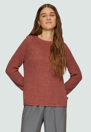 Rostfarbener Strickpullover mit strukturiertem Finish, Rundhalsausschnitt und langen Ärmeln. Es gibt eine subtile Nahtdetailierung entlang der Kanten.