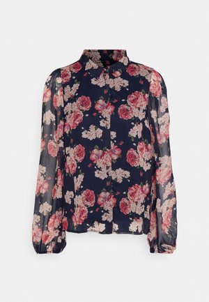 Marineblauwe semi-transparante blouse met lange pofmouwen, knoopsluiting aan de voorkant en roze-wit bloemenpatroon.