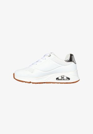 Zapatilla deportiva blanca con parte superior de piel lisa, detalles perforados, detalle en el talón en color plata y amortiguación de aire visible en la suela. Suela de goma.