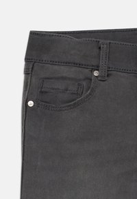 Tumedat hallid teksad, millel on eesmine tasku hõbedase nupuga ja peened õmblused. Sile tekstuur ja standardne paela disain.