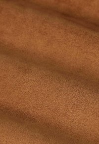 Bruin suède stof met een zachte textuur, voorzien van een gladde, matte afwerking en subtiele variaties in toon over het oppervlak.