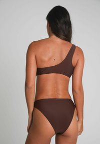 Brun bikini-set med en axelbands top och högmidjade bottnar. Släthet och minimalistisk design utan synliga mönster.
