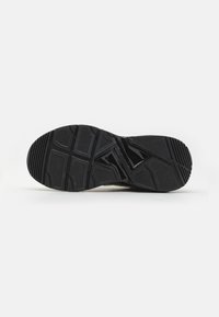 Schwarze Sportlersohle mit texturiertem Grip-Muster, die segmentierte Abschnitte für Flexibilität und Haltbarkeit aufweist, hergestellt aus Gummimaterial.