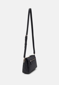 Black crossbody bag made of textured material, featuring a zip closure, adjustable strap, and decorative gold accents.