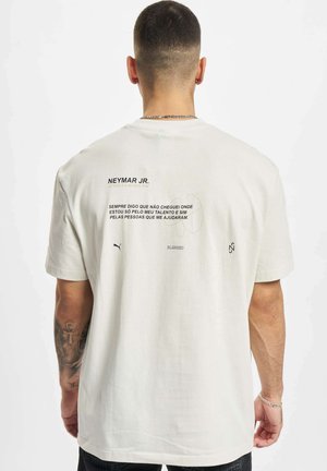 Hvit bomulls T-skjorte med trykk på baksiden som inneholder tekst og logo detaljer. Løs passform med korte ermer. Enkelt design, udekorerte stofftekstur.