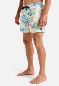 Pánske plavky v mnohobarevnom tropickom vzore. Vyrobené z ľahkého materiálu s elastickým pásom a čiernym šnúrkovým sťahovaním.