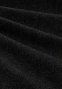 Schwarzer Baumwollstoff mit weicher Textur, der Falten und einen dezenten Glanz zeigt, mit einer glatten Oberfläche und leichter Dehnbarkeit.