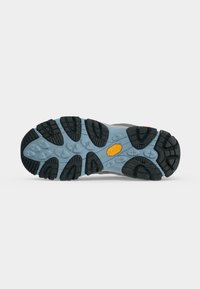 Semelle d'une chaussure de randonnée avec une base bleue et des motifs de bande de roulement noirs, avec un logo Vibram jaune au centre.