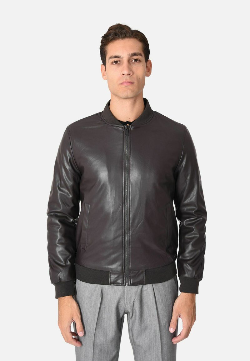 Giubbotto bomber in pelle nera con chiusura a zip, colletto e polsini a costine, dotato di tasche laterali e texture liscia. Vestibilità su misura con design minimale.
