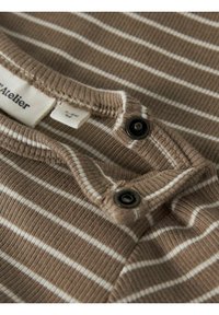 Rudo dryžuoto T marškinėlio audinys su briaunota tekstūra, su apvalia apykakle ir dviem juodais spaustukais apykaklės užsegimui.