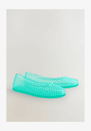 Scarpe piatte trasparenti di colore turchese con un motivo geometrico a trama aperta e punte arrotondate. Realizzate in materiale plastico flessibile.