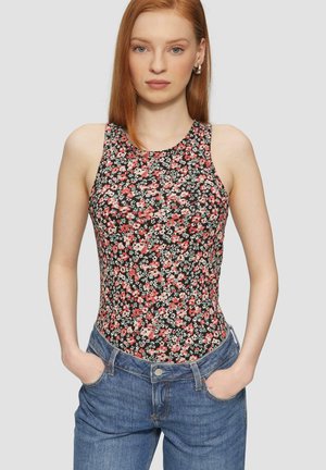 Bloemenbodysuit met een hoge hals en mouwloos ontwerp. Zwarte achtergrond met roze en witte bloemen. Gecombineerd met blauwe denim jeans.