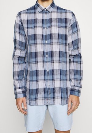 Camisa de cuadros azul y blanca con cuello abotonado, con diferentes anchos de rayas y una textura ligera. Botones en la parte delantera.