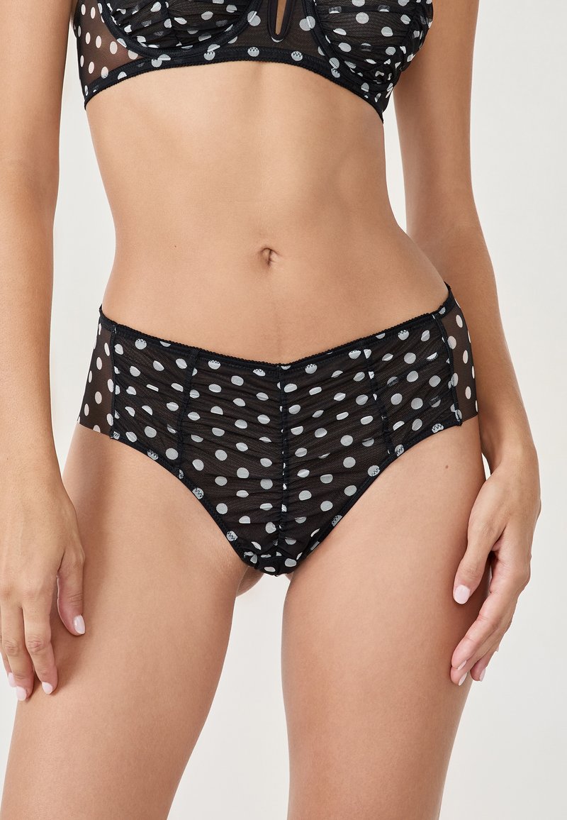 Set di lingerie nero con pois, realizzato in rete trasparente, caratterizzato da pois grigi, una texture liscia e delicate rifiniture in pizzo lungo i bordi.