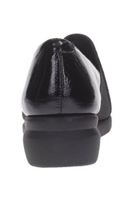 Chaussures en cuir verni noir avec un talon bas et une texture lisse, présentant un bout arrondi et un détail de couture subtil à l'arrière.