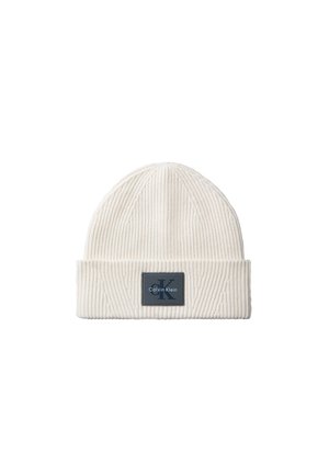 Bonnet en maille côtelée couleur crème avec revers plié et patch logo Calvin Klein noir rectangulaire au centre devant.