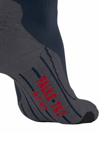 Szare i granatowe skarpetki z teksturowanym wzorem, z czerwonym napisem "FINE TUNED" i wzmocnionym palcem, głównie z prążkowanej tkaniny zapewniającej wentylację.