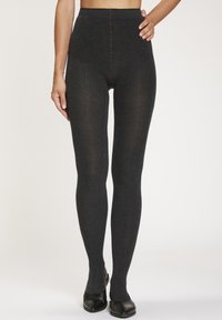 High-waisted, dark gray ribbed leggings with a textured finish, featuring a seamless design and slight sheen. Worn with black shoes.