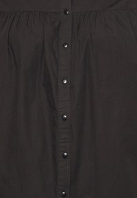 Vestido preto com botões, apresentando um corpete franzido, textura suave e silhueta reta com seis botões pretos na frente.