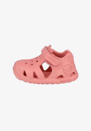 Sandalia rosa para bebé con tira ajustable, orificios de ventilación y suela texturizada sobre fondo blanco.