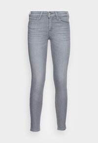 Jeans de corte skinny en denim gris claro con una textura suave, diseño de cinco bolsillos, cierre de botón y cremallera, con sutiles detalles de desgaste.