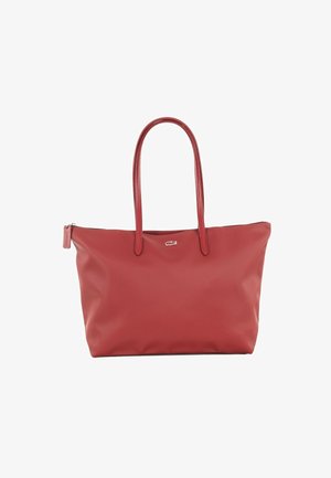 Czerwona torba typu tote marki Lacoste z podwójnymi uchwytami, zamknięciem na zamek i małym logo krokodyla na środku przodu.