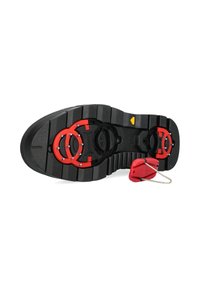 Schwarze Außensohle mit tiefen Stollen und roten Klemmvorrichtungen. Verfügt über einen gelben Dreieckindikator und einen roten Verriegelungsmechanismus.