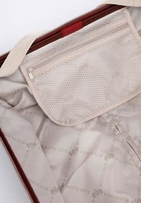 L'interno della borsa rossa è realizzato in tessuto beige con una tasca a rete e un motivo a logo dorato. Include un compartimento con zip per l'organizzazione.