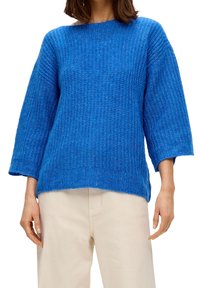 Maglione blu lavorato a maglia con vestibilità ampia, scollatura rotonda e maniche a tre quarti. La texture del materiale appare spessa e morbida.