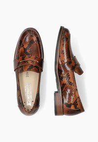 Mocassins en imprimé serpent marron avec une finition en cuir lisse, un talon bas empilé et une sangle d'accent. Comprend une marque en relief sur la semelle intérieure.