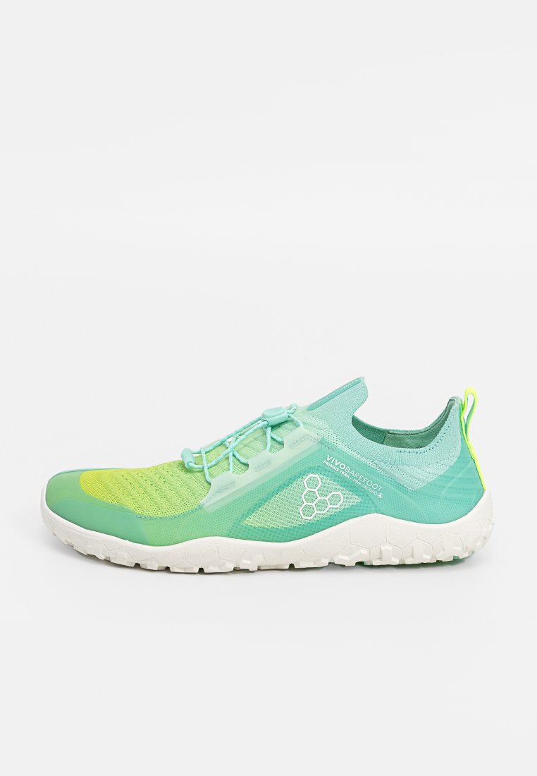 Zapatilla deportiva verde y amarilla con parte superior de malla, cierre de cordones, suela texturizada y un logotipo reflectante. Diseño suave y ligero.