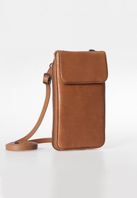 Leren schoudertas in tan kleur met een ritssluiting en een vlakke voorflap. Voorzien van een lange, verstelbare schouderband en een gladde textuur.