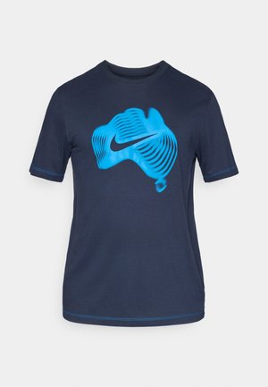 Tumši zila kokvilnas T-krekls ar lielu, stilizētu zilu grafisko dizainu un Nike logotipu priekšpusē; ar īsām piedurknēm un apaļu kakla izgriezumu.