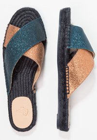 Lesklé tyrkysové a měděné espadrilky s křížovým popruhem, spletenou jutovou podrážkou a černou gumovou podešví. Hladká vnitřní podšívka.