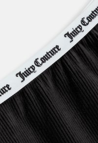 Juoda dryžuota medžiaga su balta juosta, ant kurios yra juodas „Juicy Couture“ logotipas, para�šytas kursyvu. Lygus paviršius su vertikaliomis linijomis.