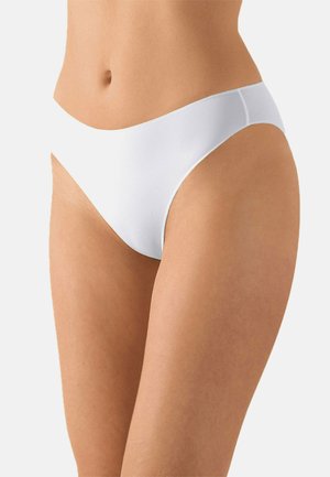 Weiblicher Oberkörper in schlichter weißer, hochgeschnittener Bikini-Unterwäsche vor neutralem Hintergrund.