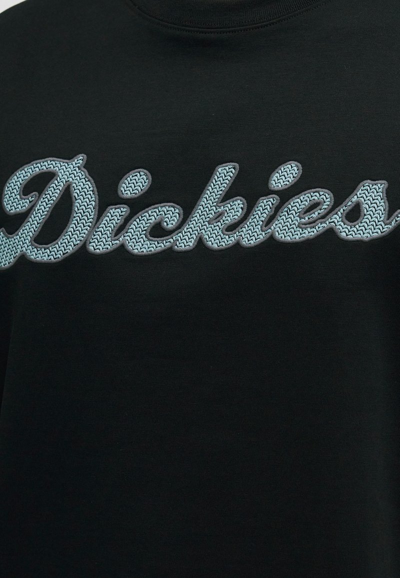Schwarzer Stoff mit hellblauem, gestricktem Schriftzug „Dickies“ im Brustbereich.