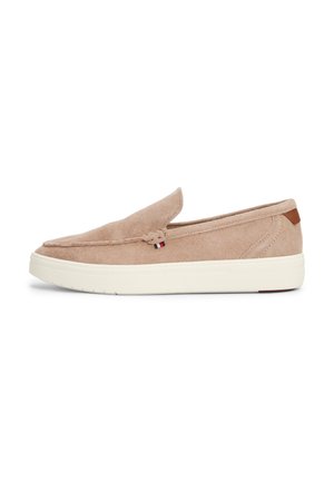 Chaussure slip-on en suède beige avec une tige douce, présentant un détail tissé et une semelle en caoutchouc blanche avec une petite accent en cuir marron.
