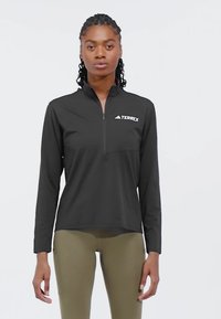 Pullover nero a maniche lunghe con zip realizzato in tessuto leggero; presenta una tasca sul petto e il logo "TERREX" sul lato sinistro.