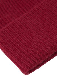 Cappello lavorato a maglia color bordeaux con una texture a costine, caratterizzato da un risvolto. Realizzato in un morbido e caldo materiale misto lana.