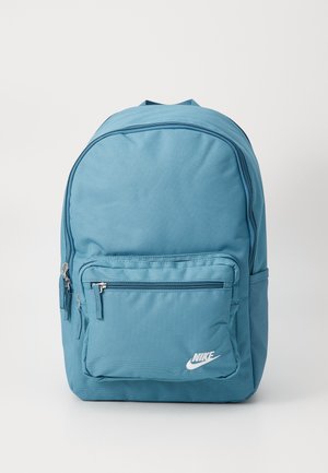Modra tkaninska nahrbtnik z teksturirano površino, ki vsebuje glavni predel in sprednji žep na zadrgo ter bel Nike logotip.