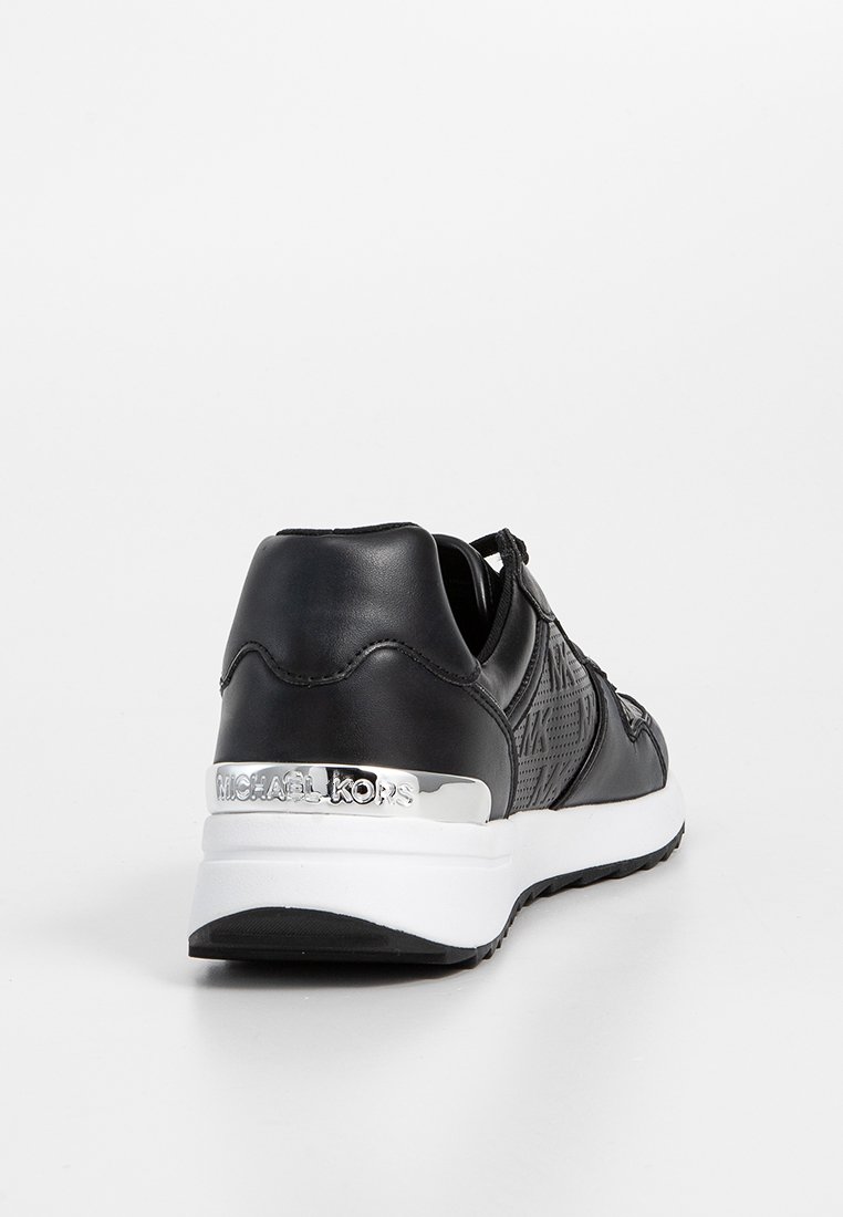 Sneaker nera con una tomaia in pelle liscia, dettagli testurizzati, marchio argentato metallizzato sul tallone e suola in gomma bianca.