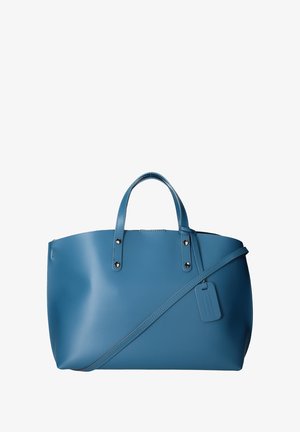 Sac fourre-tout en cuir bleu avec deux poignées et une bandoulière amovible. Doté de quincaillerie en argent et d'une étiquette de bagages. Texture lisse.