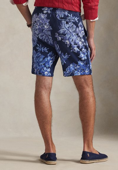 Σορτς με λουλουδάτο σχέδιο σε ναυτικό μπλε χρώμα με αποχρώσεις του μπλε και του λευκού. Μαλακό ύφασμα, μήκος πάνω από το γόνατο, με πίσω τσέπη και λεπτομέρεια με κουμπί.