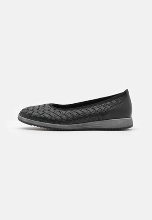 Black flat shoe with a woven texture, rounded toe, and rubber sole. Features a smooth heel and minimalistic design.